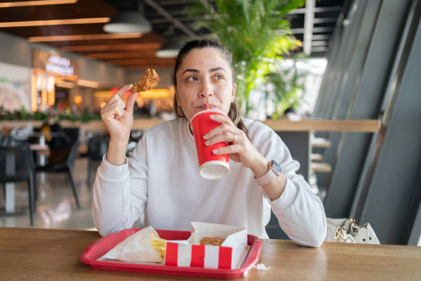 eating unhealthy fast food - junk food stock pictures, royalty-free photos & images