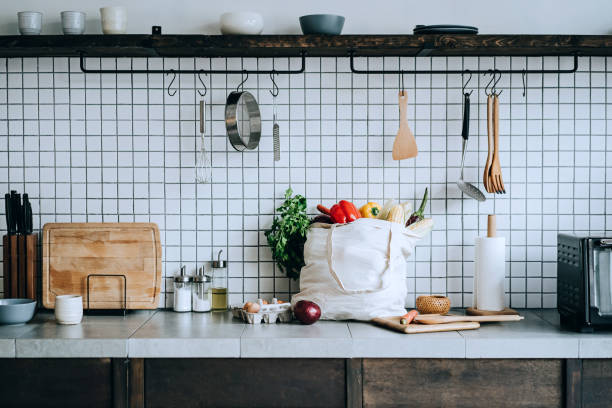 een herbruikbare tas vol kleurrijke en verse biologische groenten en boodschappen op het aanrecht. zero waste shopping en duurzaam lifestyle concept - food stockfoto's en -beelden