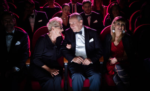 elderly couple talking while sitting in theater - concert stock pictures, royalty-free photos & images