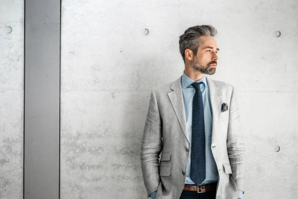elegant handsome bearded businessman standing with dog in business district - fashion stock pictures, royalty-free photos & images