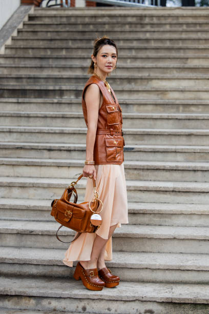 Elva Ni wears brown vest, golden necklace, skirt, brown bag outside Chloe during Womenswear Spring/Summer 2025 as part of Paris Fashion Week on...