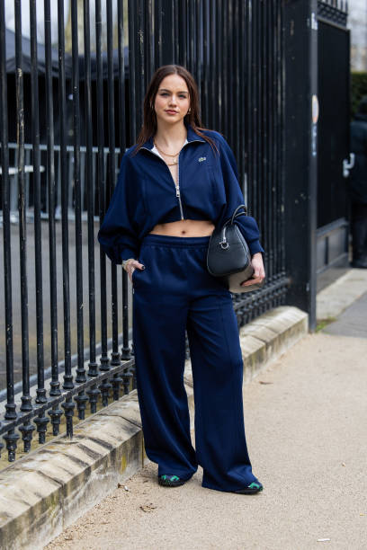 Emma Brooks wears navy zipper jacket, pants, black bag outside Lacoste during the Womenswear Fall/Winter 2024/2025 as part of Paris Fashion Week on...