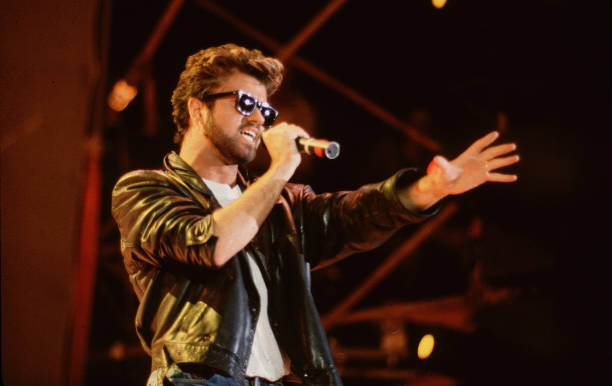 English Pop singer George Michael , of the group Wham, performs at Live Aid, Wembley Stadium, London, 7/13/1985.