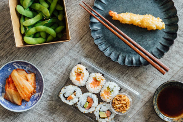 enjoying japanese takeaway meal at home - junk food stock pictures, royalty-free photos & images