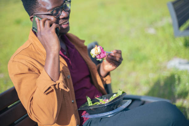 enjoying the healthy take out on the bench - junk food stock pictures, royalty-free photos & images