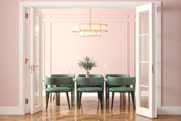entrance of dining room with dining table, green velvet chairs and pink wall in background - home decoration stock pictures, royalty-free photos & images