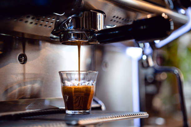 espresso drops dripping from portafilter in small coffee shop - coffee stockfoto's en -beelden