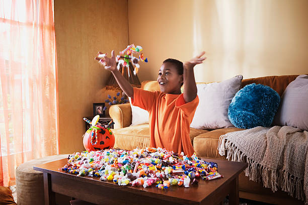excited boy with halloween candy - junk food stock pictures, royalty-free photos & images