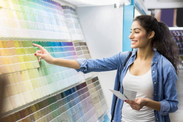 excited new home owner picks out paint color - home decoration stock pictures, royalty-free photos & images