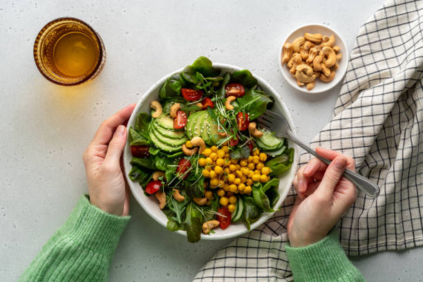 faceless female eating healthy vegan plant-based salad in bowl with fatty acids and dietary fiber - food stock pictures, royalty-free photos & images