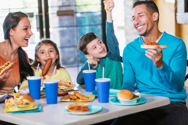 familie mit zwei kindern essen fast food - junk food stock-fotos und bilder