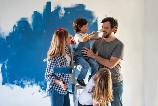 familie plezier tijdens het schilderen van hun huis - home decoration stockfoto's en -beelden