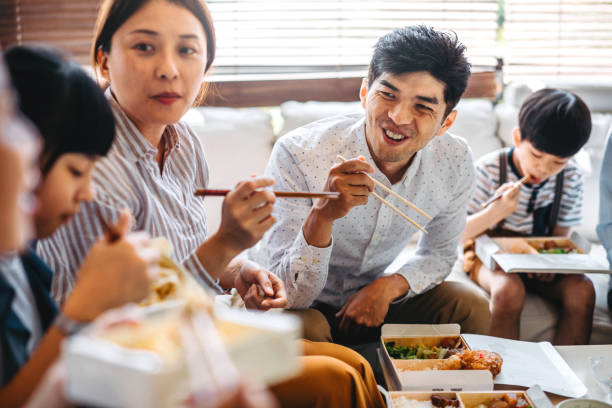 family eating takeout food in living room - junk food stock pictures, royalty-free photos & images