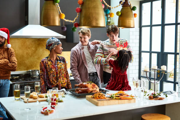 family enjoying christmas dinner preparations in kitchen - home decoration stockfoto's en -beelden