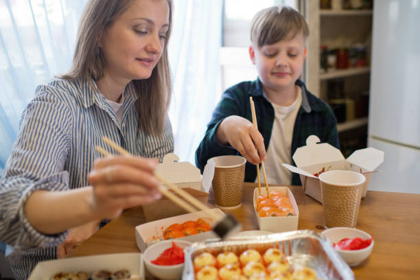 family enjoying take-out food at home - junk food stock pictures, royalty-free photos & images