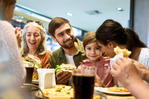 family having fun during lunch time at shopping mall's food scourt - food stock pictures, royalty-free photos & images