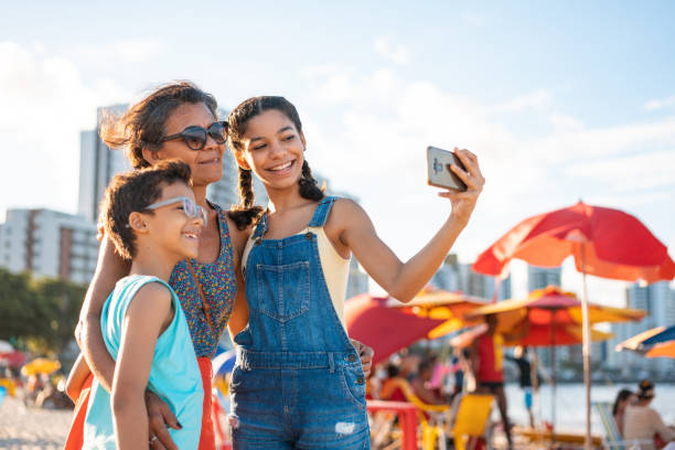 family taking a selfie on the tropical beach - travel stock pictures, royalty-free photos & images
