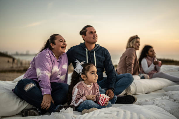 family watching a movie at outdoors cinema - concert stock pictures, royalty-free photos & images