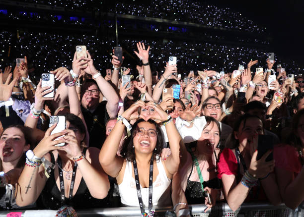 Fans watch Taylor Swift perform onstage during night two of "Taylor Swift | The Eras Tour" at La Defense on May 10, 2024 in Paris, France.