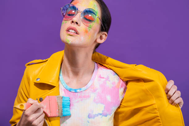 fashion artist painter girl with brush painting herself t-shirt on purple - fashion stock pictures, royalty-free photos & images