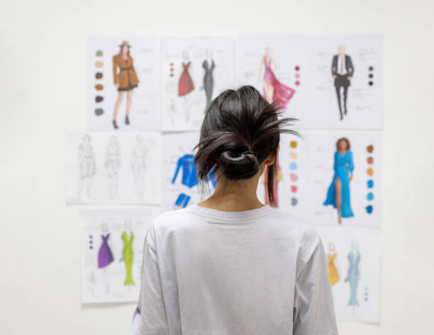 fashion design student looking at sketch illustrations at the atelier - fashion stock pictures, royalty-free photos & images