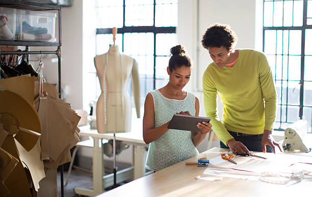 fashion designers working together in their studio - fashion stock pictures, royalty-free photos & images