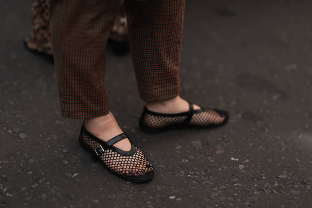 Fashion Show Guest was seen wearing brown and green ckecked trousers and black shoes with a black net on it before the Huishan Zhang Fashion Show...