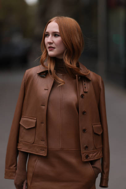 Fashion week guest is seen wearing a brown short dress with pockets, including a brown turtleneck with long sleeves and a brown leather jacket. She...