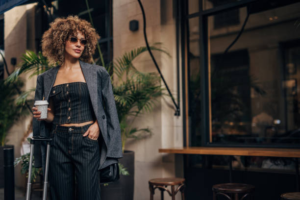 fashionable woman enjoying coffee in the city - fashion stock pictures, royalty-free photos & images