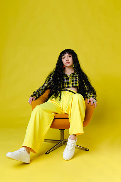 fashionable woman standing against plain background - fashion stock pictures, royalty-free photos & images