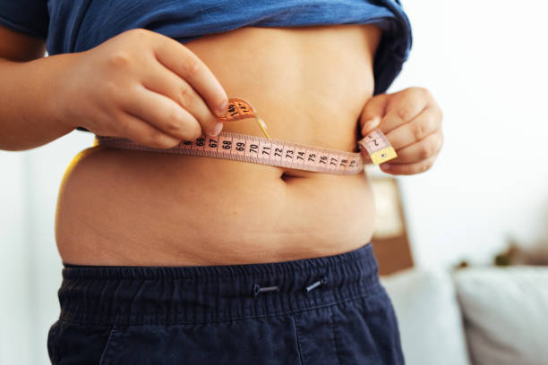 fat boy measuring his belly - junk food stock pictures, royalty-free photos & images