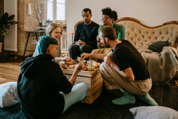 female and male friends having breakfast in living room at home - food stock pictures, royalty-free photos & images