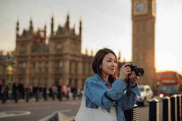 female asian tourist taking photos with camera while exploring the city of london - travel stock pictures, royalty-free photos & images