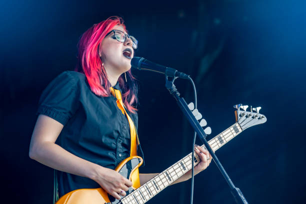 female bassist and signer performing live - concert stock pictures, royalty-free photos & images