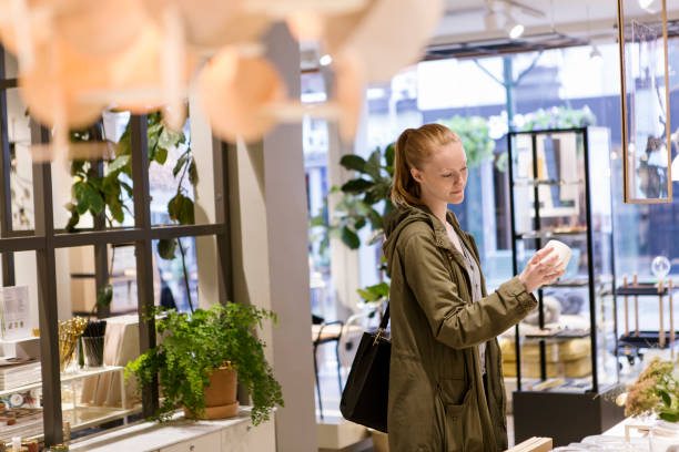 female customer looking at object while standing in store - home decoration stock pictures, royalty-free photos & images