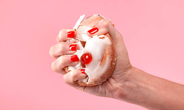 female dieter crushing belgian bun - junk food stock pictures, royalty-free photos & images