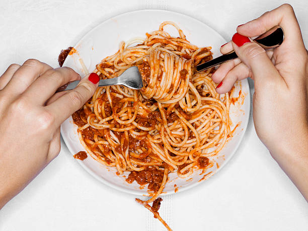 female eating spaghetti, overhead view - junk food stock pictures, royalty-free photos & images
