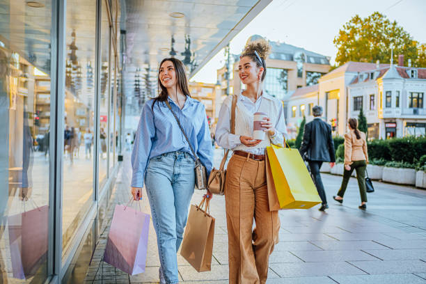 female friends looking at store window - fashion stock pictures, royalty-free photos & images