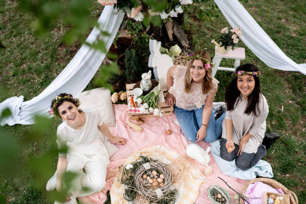 female friends on easter egg hunt in blooming spring garden - garden decoration stock pictures, royalty-free photos & images
