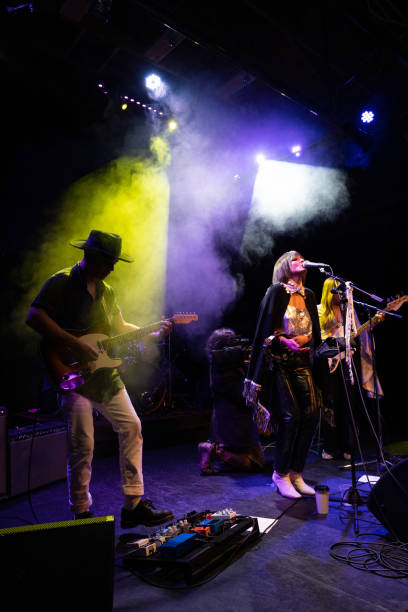 female fronted rock band performing live on stage - concert stock pictures, royalty-free photos & images