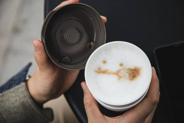 female hand holding a reusable coffee cup outdoor - junk food stock pictures, royalty-free photos & images