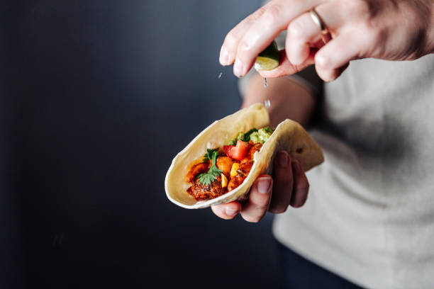 female hand squeezing lime into vegan tacos - food stock pictures, royalty-free photos & images