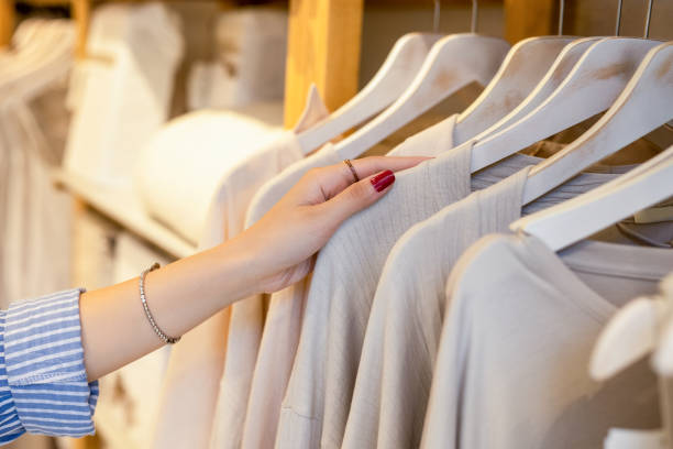 female hand taking a clothes out at clothing store - fashion stock pictures, royalty-free photos & images