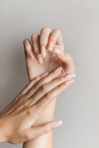 female hand with long nail polish manicure in beige glossy color. - nails art stock pictures, royalty-free photos & images