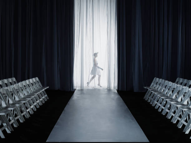 female model (15-17) walking backstage at fashion show, side view - fashion stock pictures, royalty-free photos & images