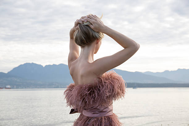 female model looks out across bay to city, hills - fashion stock pictures, royalty-free photos & images