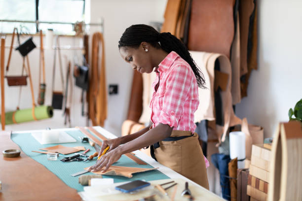 female small business owner working in her leatherwork studio - fashion stock pictures, royalty-free photos & images