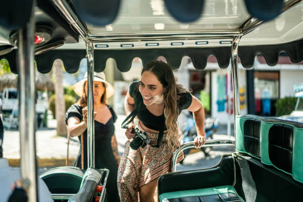 female traveler friends entering a local taxi - travel stock pictures, royalty-free photos & images