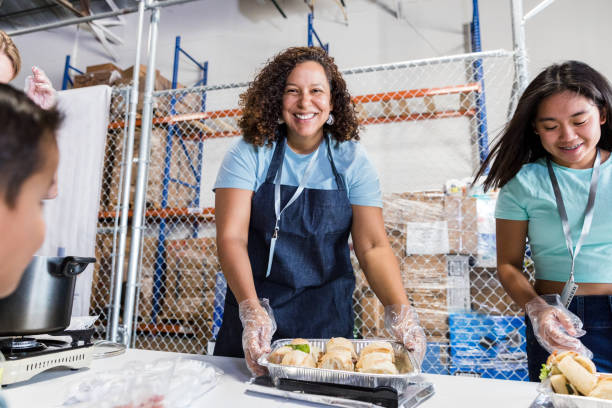 female volunteer smiles for the camera - food stock pictures, royalty-free photos & images