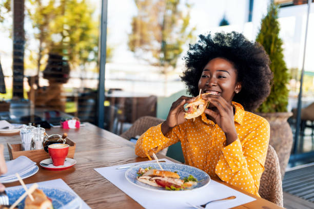 femme appréciant le sandwich de manger au restaurant - food photos et images de collection